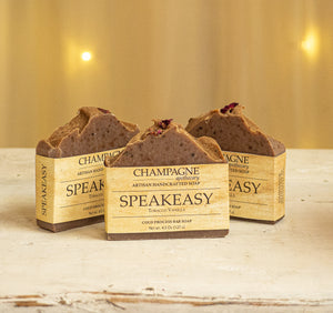 Our signature scent Speakeasy soap has a nostalgic, warm scent characterized by tobacco leaves reminiscent of days past; balanced with timeless, sugary vanilla.  These soaps are handmade locally using local raw honey & infused with dried rose petals. All natural butters and oils give this soap a rich, creamy lather leaving your skin feeling cleansed and refreshed. Found at Champagne Apothecary at School Street in Westfield, Massachusetts.  A small business collaboration with Budsuds® Soapery.