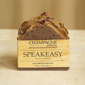 Our signature scent Speakeasy soap has a nostalgic, warm scent characterized by tobacco leaves reminiscent of days past; balanced with timeless, sugary vanilla.  These soaps are handmade locally using local raw honey & infused with dried rose petals. All natural butters and oils give this soap a rich, creamy lather leaving your skin feeling cleansed and refreshed. Found at Champagne Apothecary at School Street in Westfield, Massachusetts.  A small business collaboration with Budsuds® Soapery.